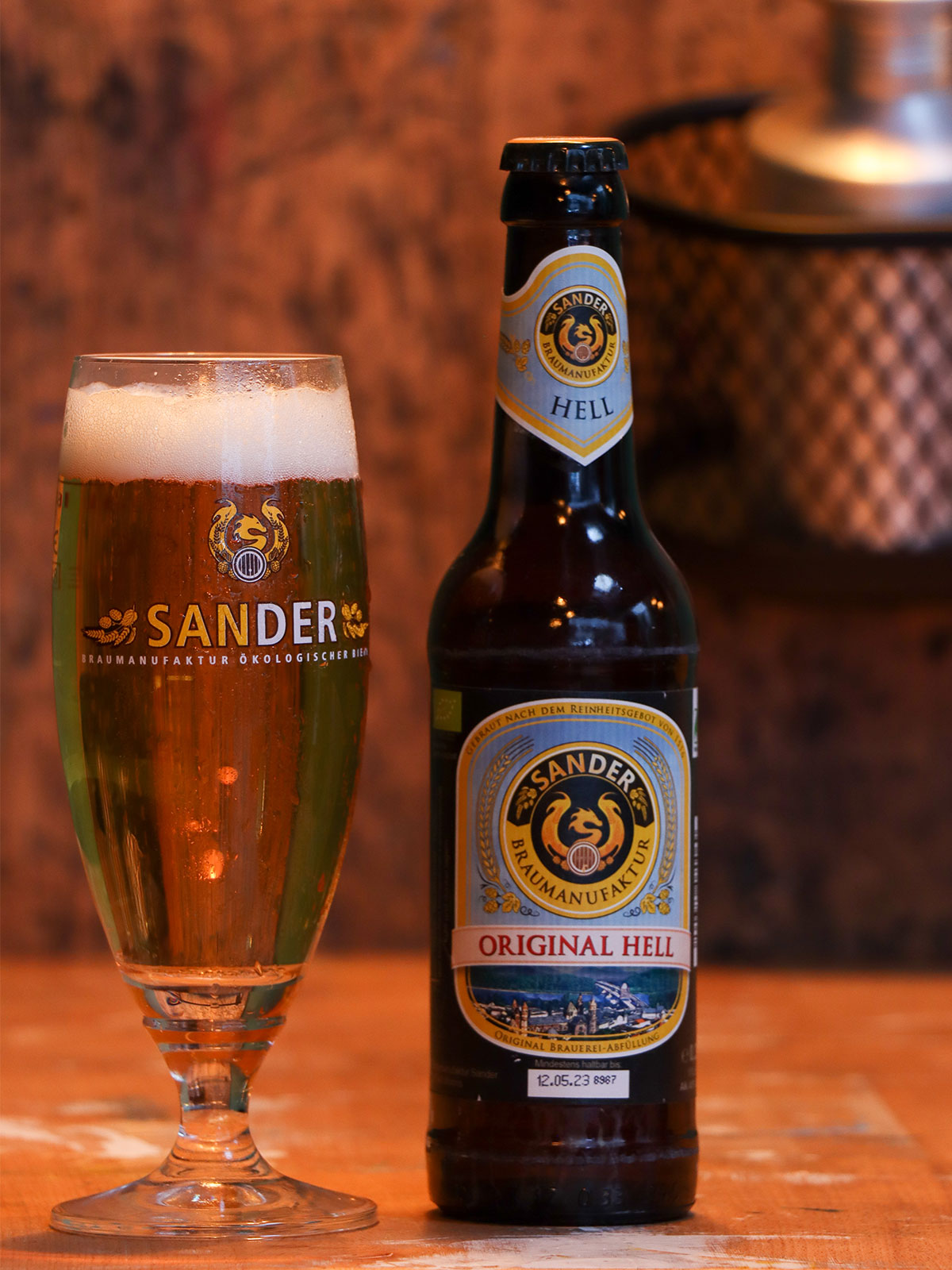 Bierglas und eine Flasche mit Privatbrauerei Sander Logo